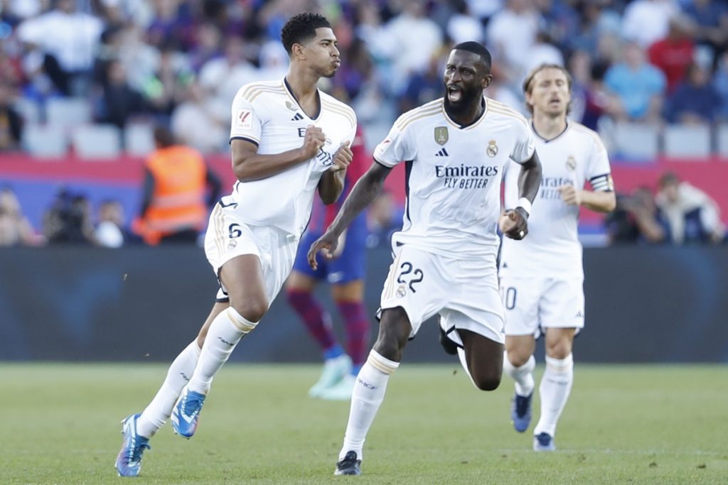 Real Madrid's midfielder Jude Bellingham (L) jubilates with his teammate Antonio Rudiger