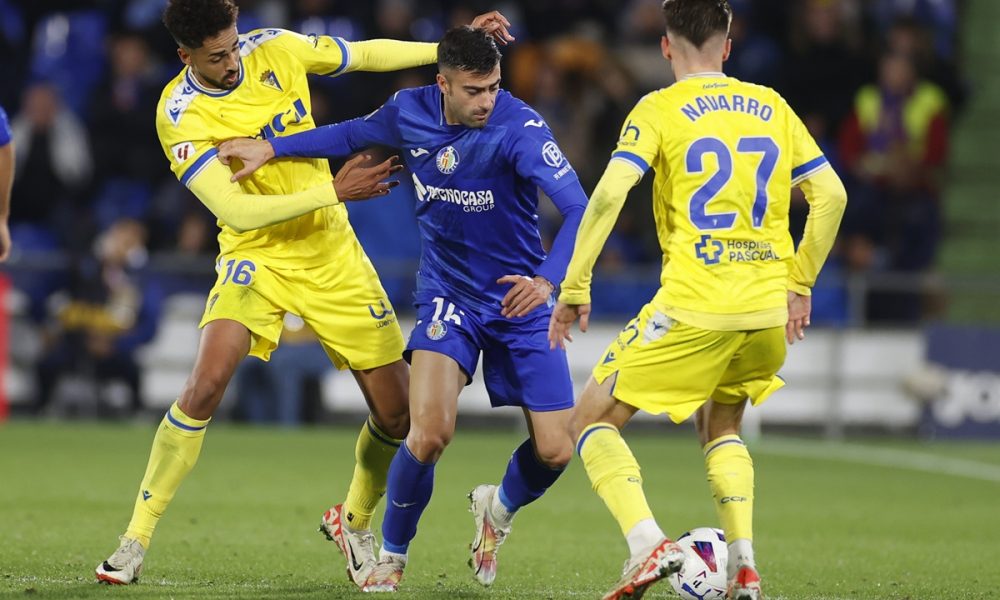 Getafe's defender Diego Rico (C) in action against Cadiz's striker Chris Ramos (L) and midfielder Robert Navarro (R)