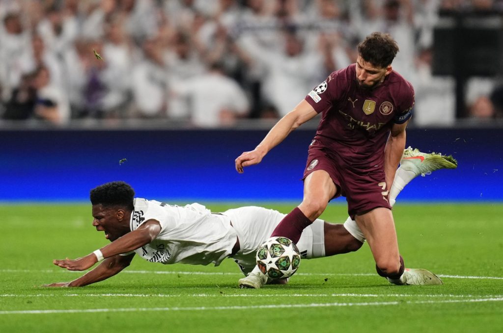 Real Madrid's Aurelien Tchouameni (left) and Manchester City's Ruben Dias in action during the UEFA Champions League Knockout Phase Play Offs Second Leg match at Santiago Bernabeu, Madrid. Picture date: Wednesday February 19, 2025.