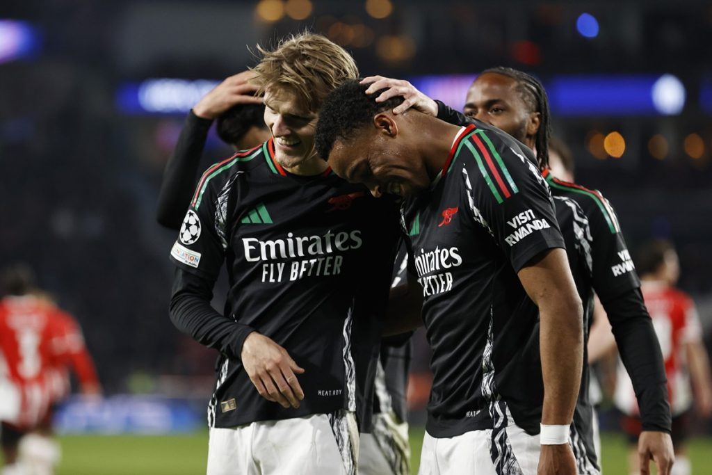 epa11940886 Martin Odegaard of Arsenal FC celebrates scoring the 1-6 goal with his teammate Jurrien Timber (R) during the UEFA Champions league round of 16 first leg soccer match between PSV Eindhoven and Arsenal FC in Eindhoven, the Netherlands, 04 March 2025. EPA/MAURICE VAN STEEN